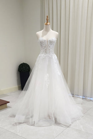 White wedding dress on a mannequin against a neutral background