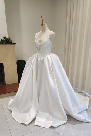 White wedding dress on a mannequin against a neutral background
