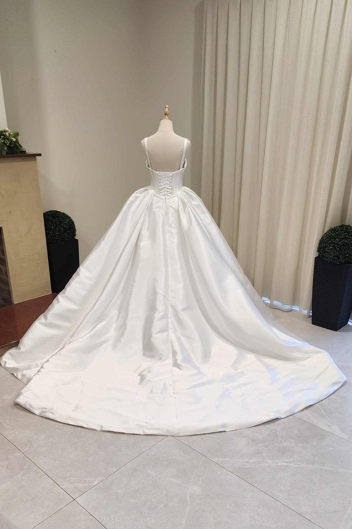 White wedding dress on a mannequin against a neutral background