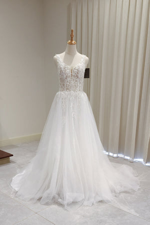 White wedding dress on a mannequin against a neutral background