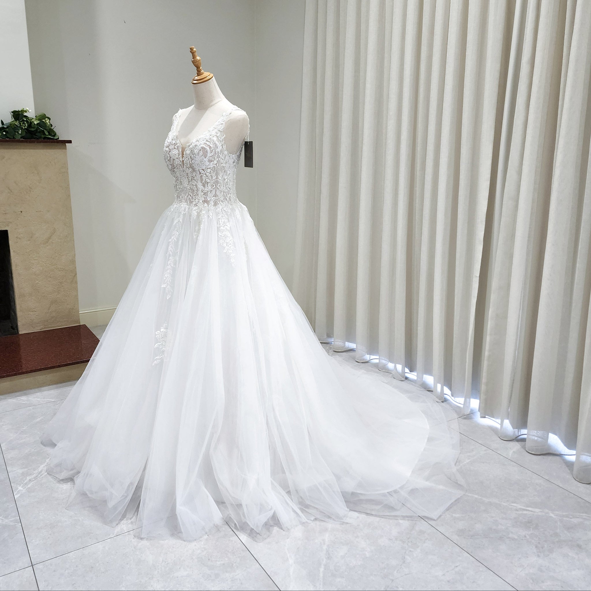 White wedding dress on a mannequin against a neutral background
