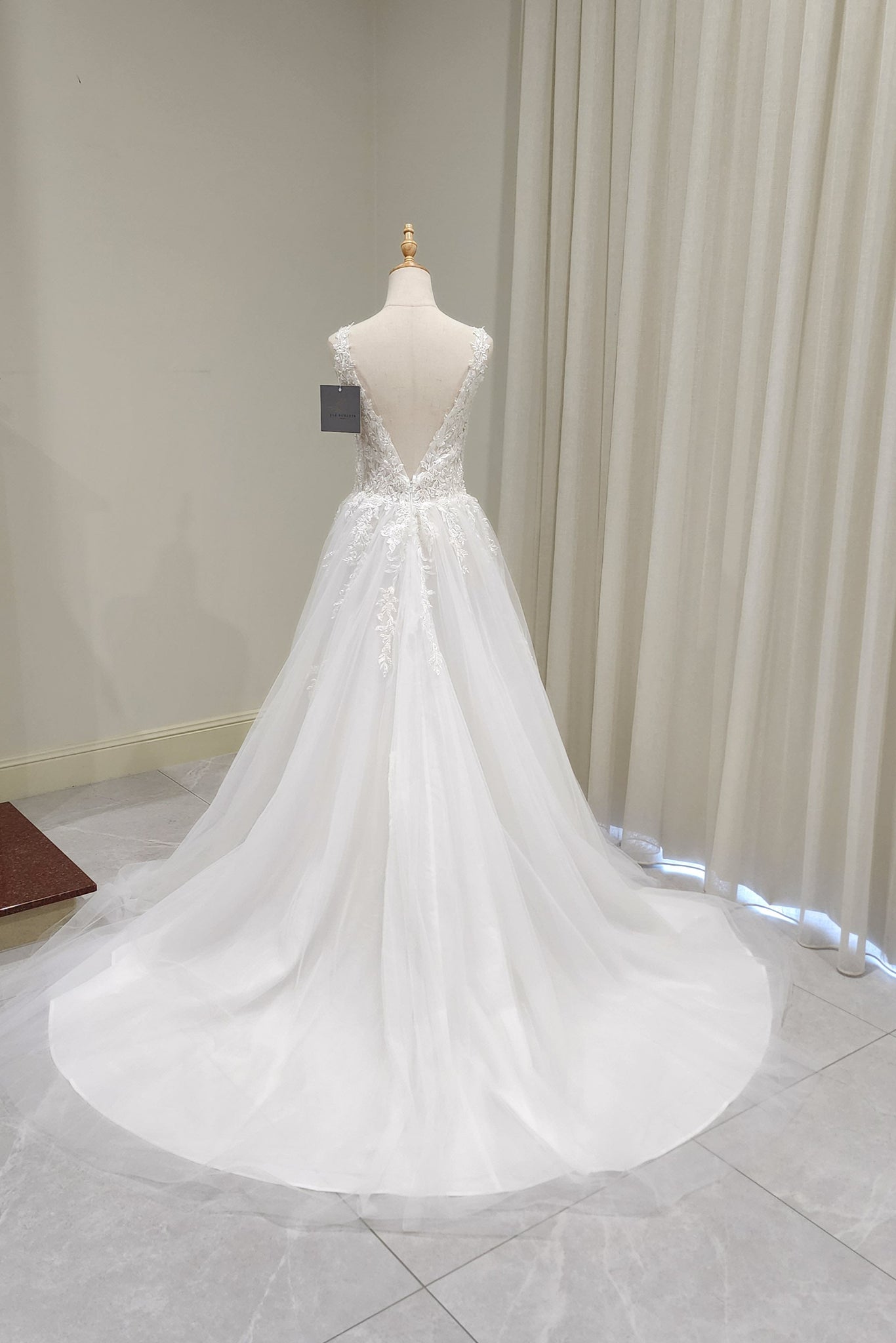 White wedding dress on a mannequin against a neutral background